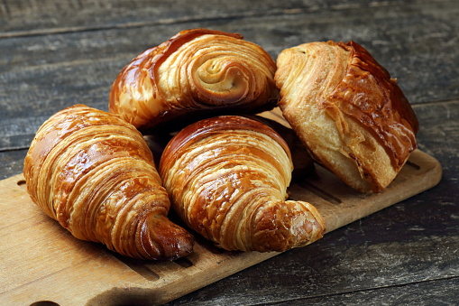 croissant and chocolate bread on wooden board