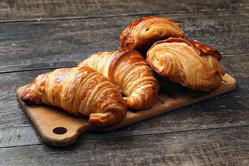 croissant and chocolate bread on wooden board