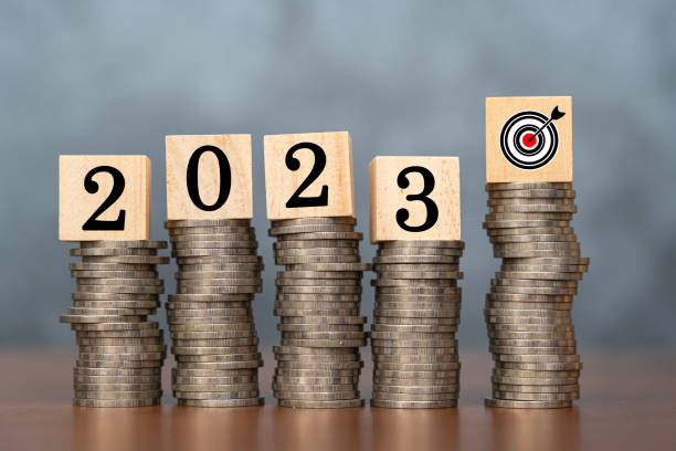 istock 2023 wooden cube and target on stack of coins with dark background and copy space. Money saving ideas and financial plans for investments. 1494437881