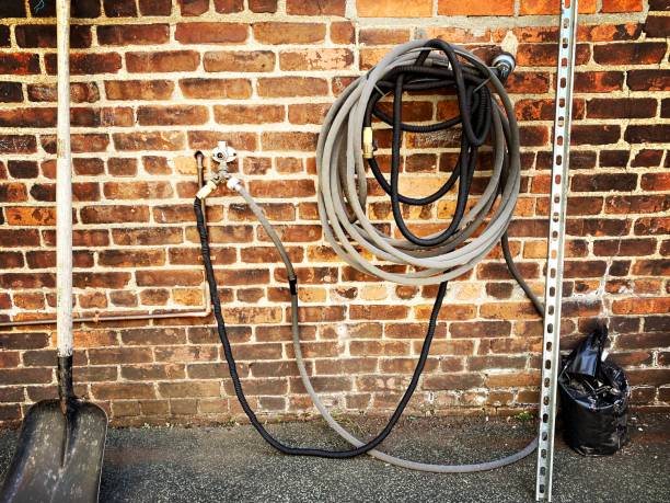 istock Water Spout, shovel and Hose on a Brick Wall 1494442561