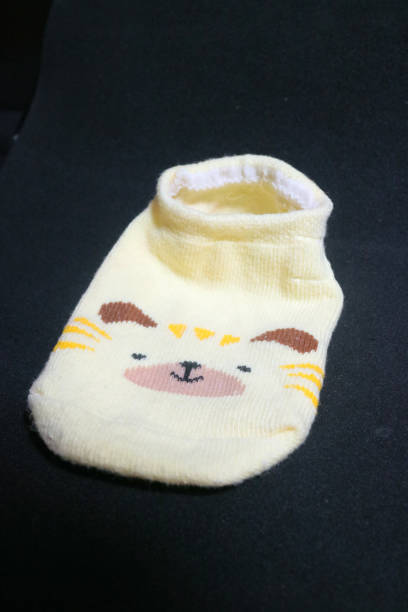 istock Cute baby socks yellow with a hamster face on them 1494442643