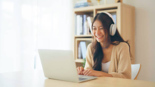 istock Young asian woman wearing headset while working on computer laptop at house. Work at home, Video conference, Video call, Student learning online class 1494460658