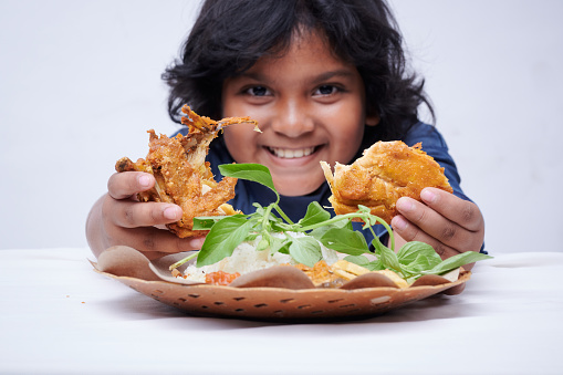 Asian little Girl Holding Fried Chicken with vegetable