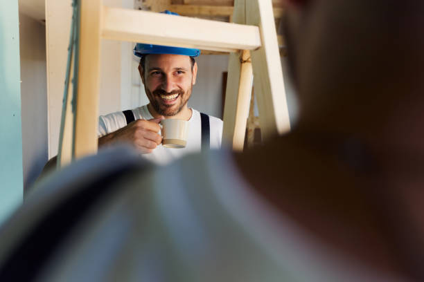 istock Happy worker talking to his colleague on a break at construction site. 1494476360