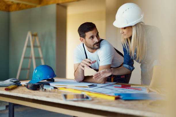 istock Female inspector and manual worker reading housing plans at construction site. 1494477229