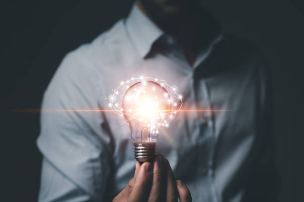 istock Hand of Man holding light bulb on dark blackground. Idea innovation and creativity concept. Innovative technology and business development 1494479625