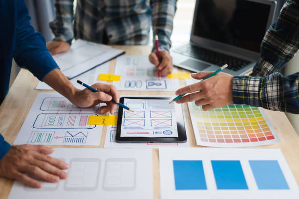 istock Close up view of UI developer team brainstorming on their project with laptop, smartphone and digital tablet. Creative digital development agency. 1494480333