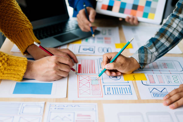 istock Close up view of UI developer team brainstorming on their project with laptop, smartphone and digital tablet. Creative digital development agency. 1494480334