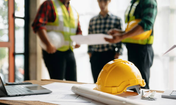 los equipos de ingenieros que se reúnen trabajando juntos usan cascos de trabajadores en el sitio de construcción en la ciudad moderna. equipo profesional de la industria asiática - albañil fotografías e imágenes de stock