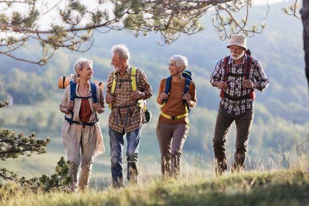 istock Happy senior friends talking while hiking through the woods. 1494480507