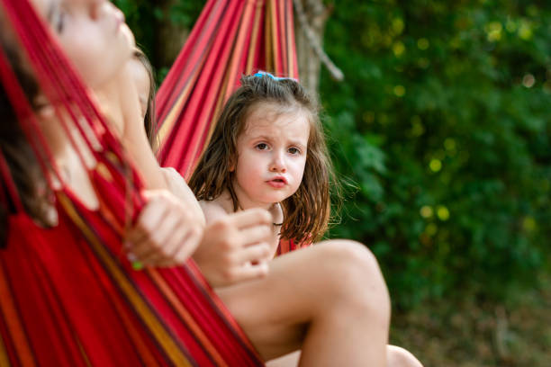 Children in hammock during summer day in nature
