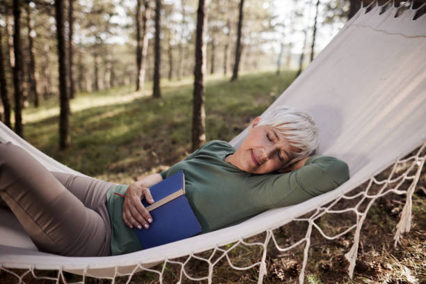 istock Smiling senior woman taking a nap in hammock. 1494480976