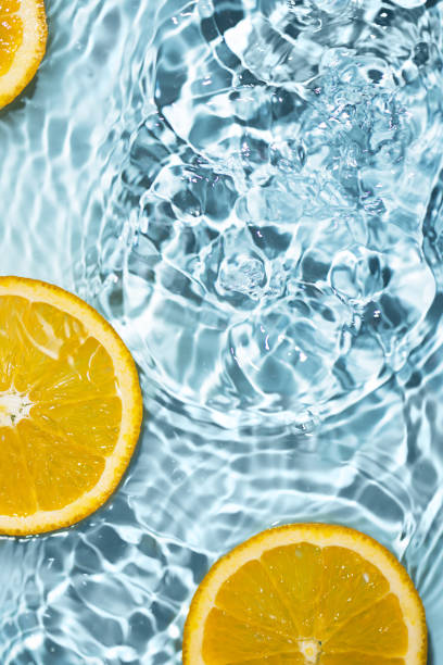 istock Creative summer background with orange fruit slices in swimming pool water. 1494482556