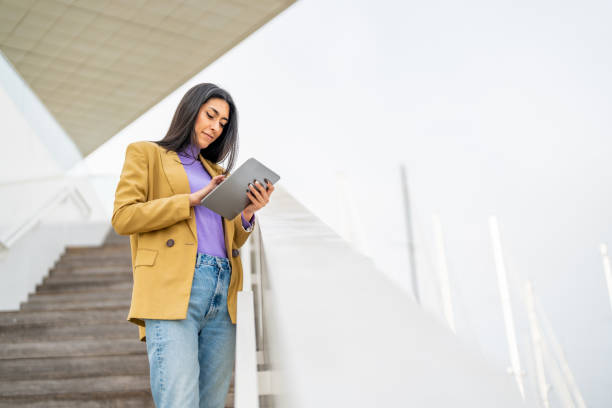istock Beautiful young woman using tablet in the city 1494483686