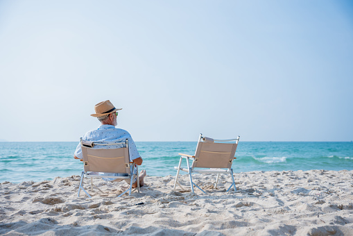 Senior couple relaxing and sitting at tropical beach., Healthy seniors lifestyle concept.