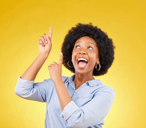 istock Studio promotion, excited and black woman point up at mock up space, advertising mockup or marketing promo. Commercial girl, gesture and happy person with product placement deal on yellow background 1494485607