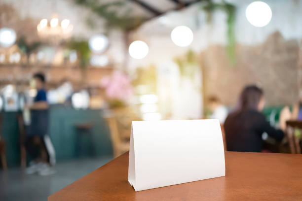 istock Blank menu frame label mockup. Menu frame mockup n wooden table in bar restaurant, stand for booklet with white sheet of acrylic paper tent card 1494489037