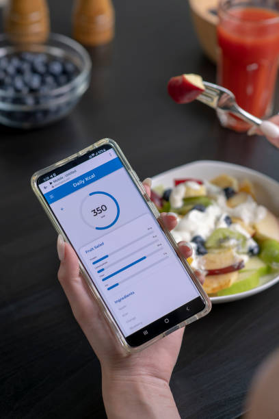 istock Woman checking calories and nutrients app on her phone while having a meal 1494492993