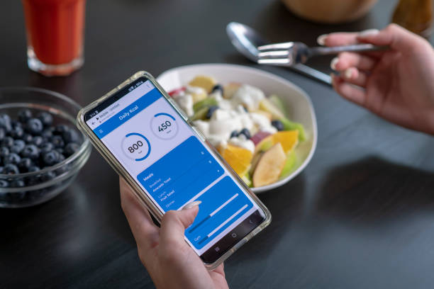 istock Woman checking calories and nutrients app on her phone while having a meal 1494492994