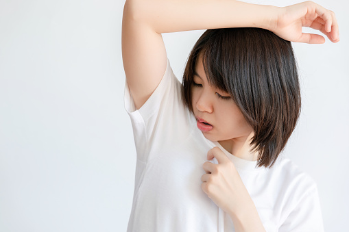 Woman raising her arms because of sweating under armpits.