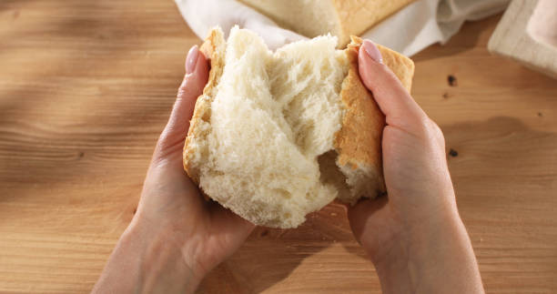 istock Female hands tear fresh bread. Texture of bread close up. 1494493266