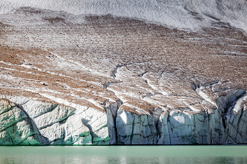 Glacier that reaches the lake in the form of a cliff. Lines carved into the front to indicate cracks created by high temperatures. Silent and soft tones color the landscape in Banff National Park in the state of Alberta in Canada.
