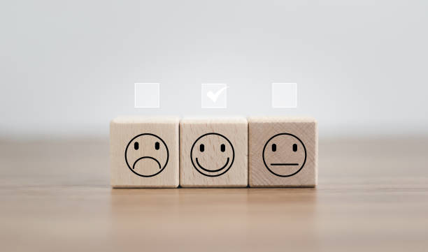 istock Customer Experiences review satisfaction feedback survey concept, satisfaction, Client give rating to service ,feedback review, good quality. Hand of a businessman chooses a smile face on wood block. 1494494438