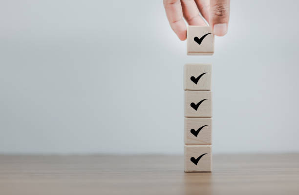 istock Quick checklist and clipboard task management, Task list, Survey and assessment. Quality Control. Hand holding Check mark on wooden blocks for complete check list. filling survey forms online. 1494494455