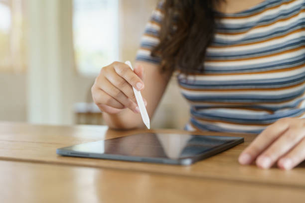 istock Woman holding a book device reading on e-book on digital tablet device or social media apps online ecommerce. 1494495492