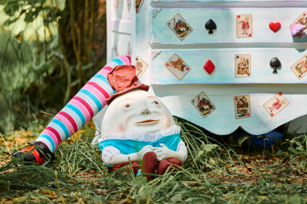 dresser with doll alice inside near humpty dumpty and mushrooms art object on outdoor art exhibition - humpty dumpty imagens e fotografias de stock
