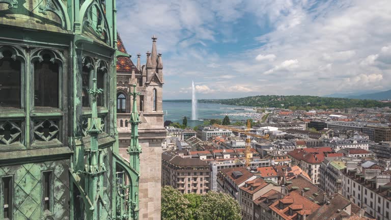 Geneva (Geneve) Switzerland time lapse 4K, high angle view city skyline timelapse at Lake Geneva and Jet d'eau fountain with tower of Saint Pierre Cathedral