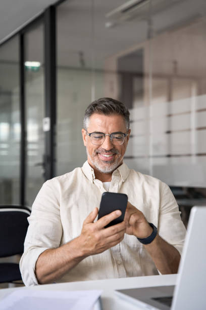 istock Vertical portrait of middle aged Hispanic business using cell phone mobile app. 1494498492