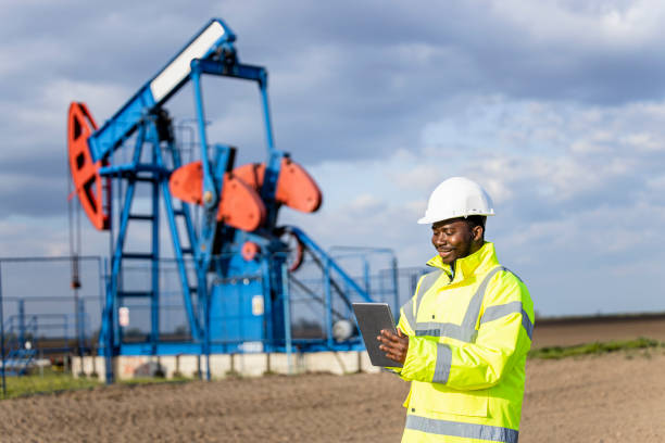 przemysł naftowy i gazowy. pracownik kontrolujący produkcję ropy naftowej. - oil industry digital tablet manual worker mining zdjęcia i obrazy z banku zdjęć