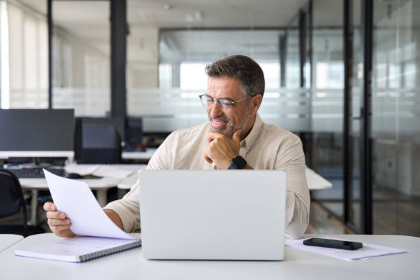 istock Focused Hispanic businessman doing paperwork in office with copy space. 1494498535