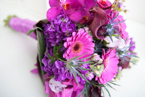 Variation of purple flower wedding bouquet on table.