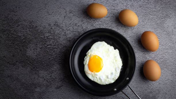 istock Top view of Breakfast menu fried eggs in an iron pan and raw chicken eggs. 1494500664