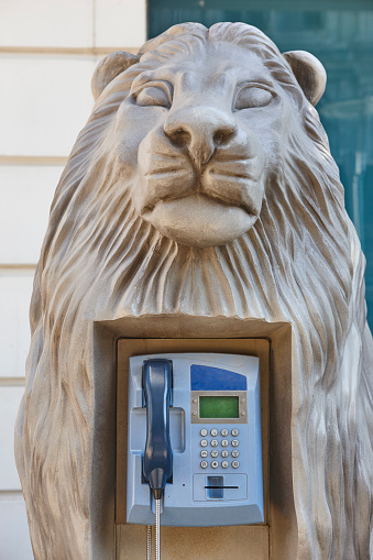 Picturesque street telephone cabintet inside a lion head sculputure