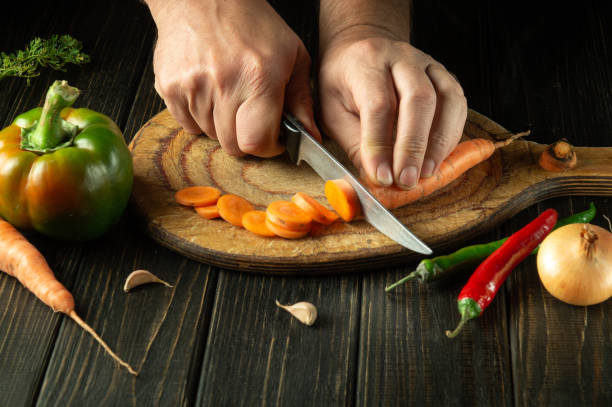 istock The chef cuts carrot on a cutting board for preparing a vegetarian lunch or breakfast. Delicious healthy food 1494503460