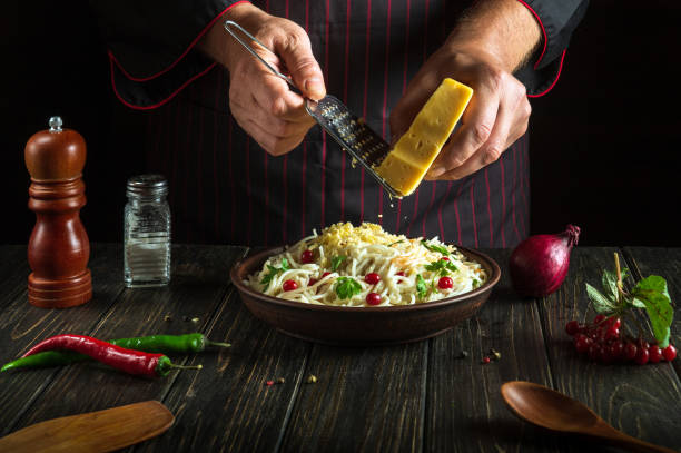istock The cook adds hard cheese to spaghetti with spices and herbs in a plate. Working environment in a restaurant kitchen. 1494504591
