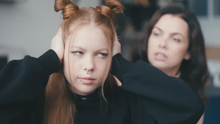 Teenage girl with attitude ignoring mom and closing ears, communication problem