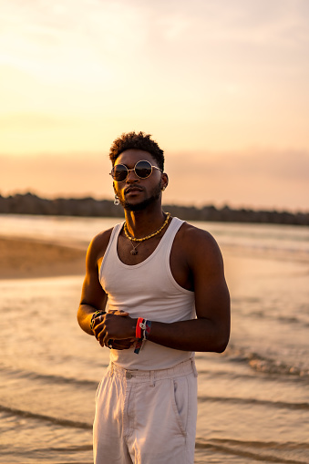 Portrait of black ethnicity model enjoying summer vacation by the sea wearing sunglasses