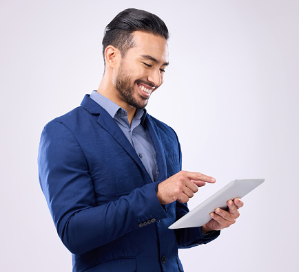 Man, business and tablet with a smile in studio for communication and network connection. Asian male model isolated on a gray background with tech for mobile app, online chat and search on internet