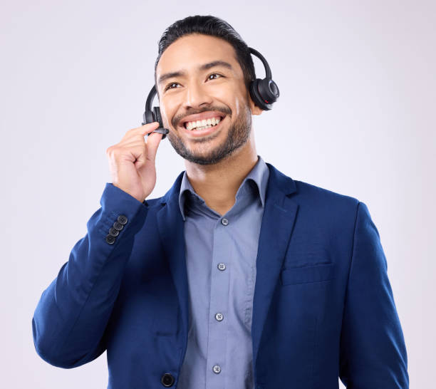 istock Thinking, customer service and smile with a man consulting using a headset for support in studio on a gray background. Idea, contact us and crm with a happy male consultant talking over a microphone 1494512798