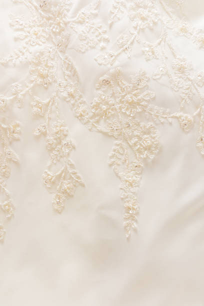istock Delicate beautiful embroidery with beads and sequins on beige satin fabric. Vertical wedding background. 1494512901