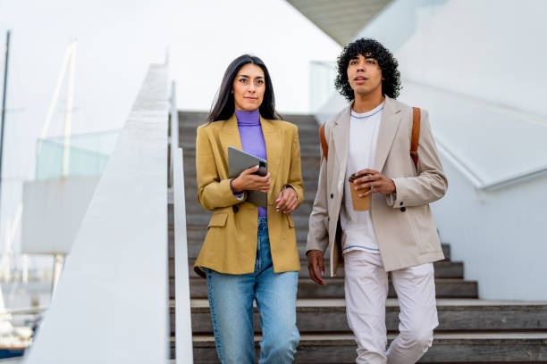 istock Coworkers talking while moving down stairs in city 1494513147