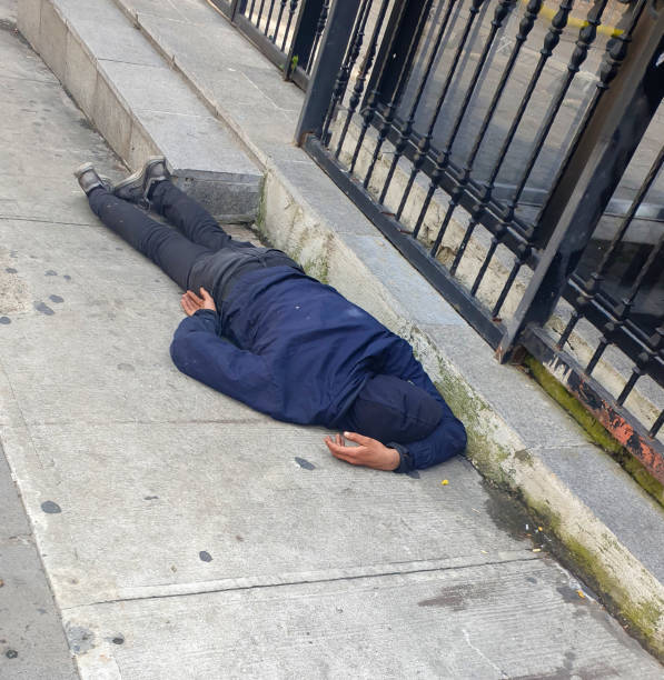 Homeless male sleeping rough in subway tunnel stock photo