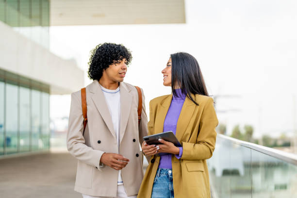 istock Two students talking to each other after classes while walking in university campus outdoors. 1494513433
