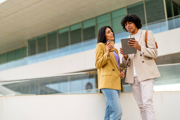 istock Young couple checking phone together while standing outdoors. 1494513818