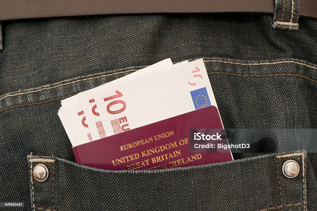 Travel Close up of European Union currency and a British passport in the back pocket of some denim jeans. Passport Stock Photo