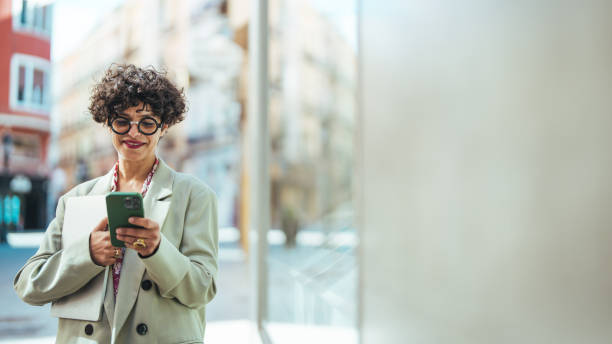 Woman texting with smartphone outdoors.